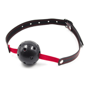 Bavaglio con sfera traforata nera, fascia elastica rossa e cinturino nero con cuciture rosse, fotografato in vista angolata su sfondo chiaro.