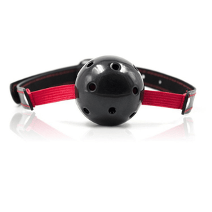 Vista frontale di un bavaglio con sfera traforata nera, fascia rossa e cinturino nero con dettagli rossi su sfondo chiaro.