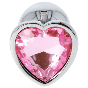 Dettaglio frontale di plug anale in metallo con grande cristallo rosa a cuore incastonato su sfondo chiaro.