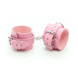 Coppia di polsini regolabili rosa in ecopelle con fibbie metalliche e collegamento centrale, vista frontale su sfondo bianco.