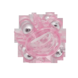 Anello in silicone rosa traslucido texturizzato con sfere argentate e rilievi morbidi, vista frontale su sfondo chiaro.