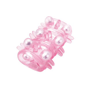 Anello in silicone rosa traslucido texturizzato con sfere argentate, mostrato in vista obliqua per evidenziare la struttura e i dettagli laterali.
