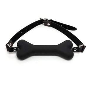 Morso a forma di osso in silicone nero con cinturino regolabile nero, vista frontale su sfondo bianco.